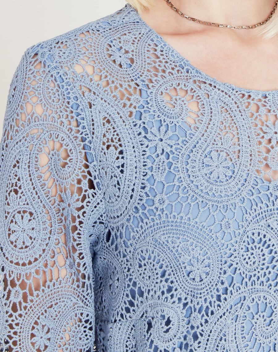 A Blusa Trancoso é confeccionada em renda de algodão, garantindo toque macio, caimento leve e sofisticação natural. É ideal para ocasiões especiais ao ar livre, celebrações diurnas ou looks resort chic elegantes e frescos.