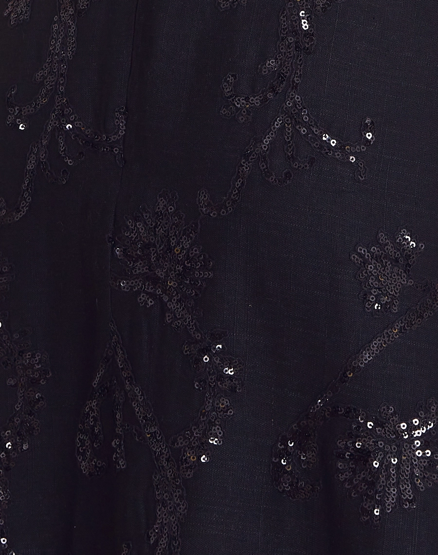 Vestido Midi Analu é confeccionado em linho misto bordado, com faixa na cintura e paetês delicados. Elegância romântica para eventos e ocasiões especiais.