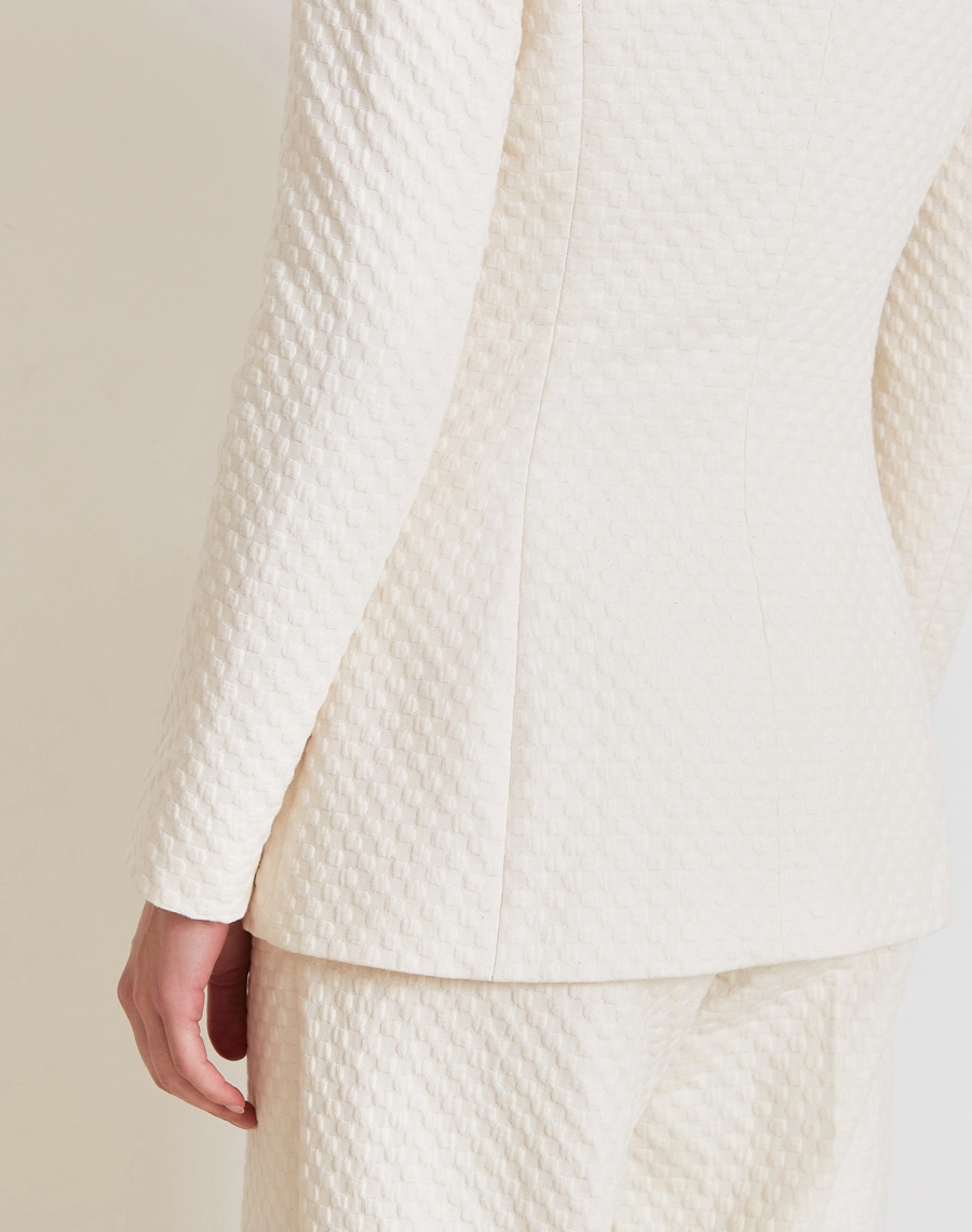 O Blazer Ariadna é confeccionado Jacquard, tecido de alta qualidade, com textura em relevo e desenho sofisticado que valoriza a peça com um visual elegante e refinado.