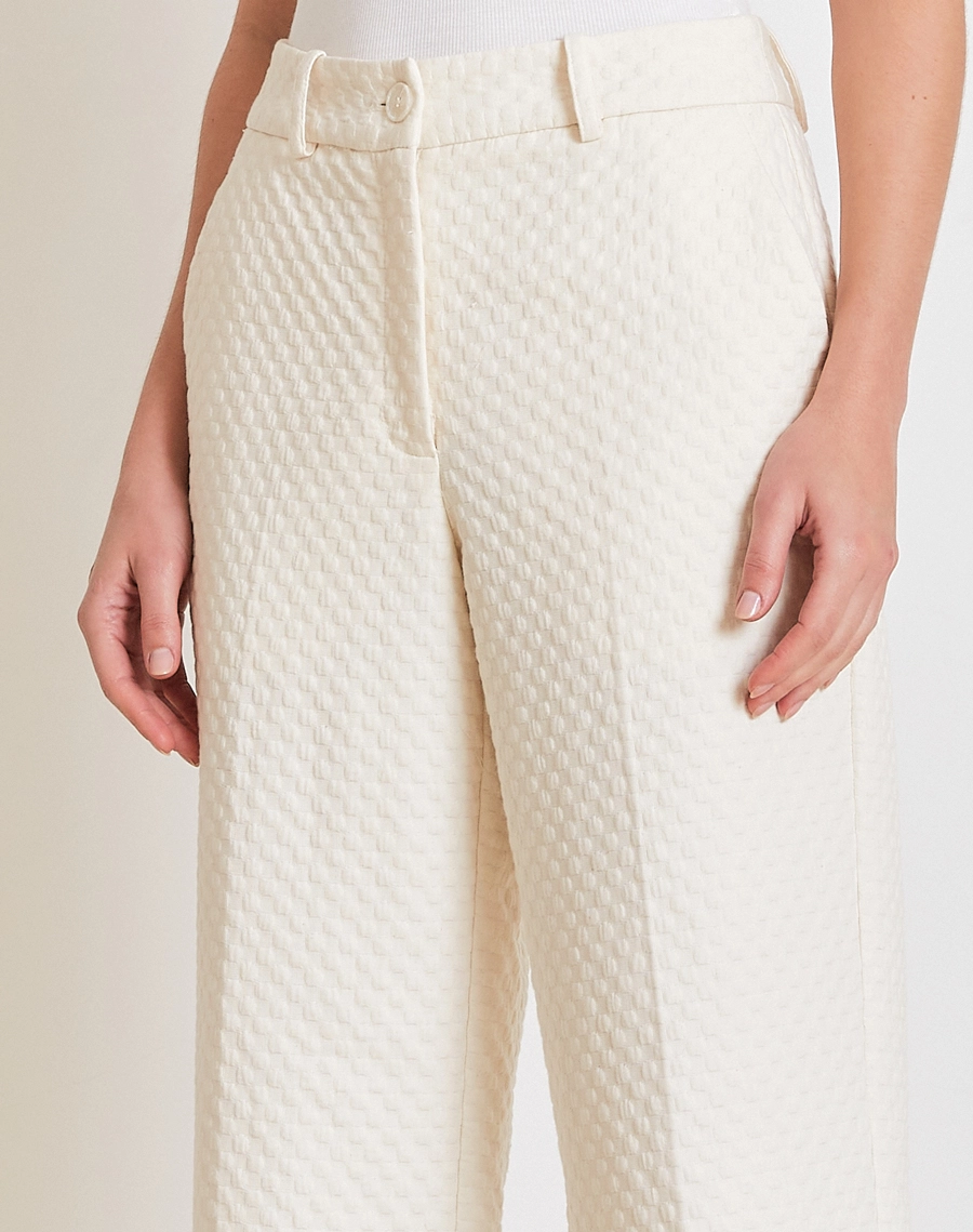 A Calça Ariadna é confeccionada em Jacquard, tecido com toque levemente encorpado que proporciona estrutura sem abrir mão do conforto. 