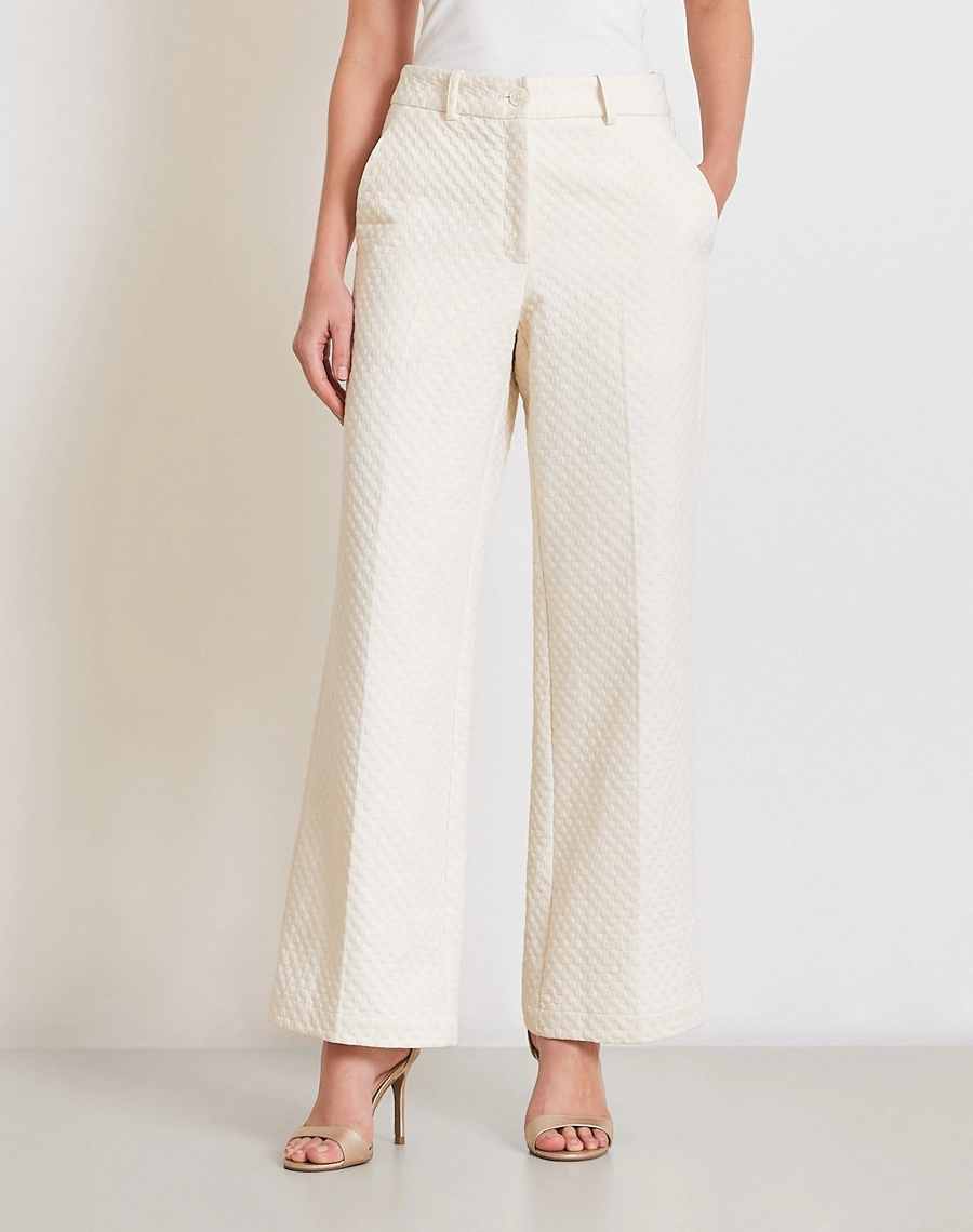 A Calça Ariadna é confeccionada em Jacquard, tecido com toque levemente encorpado que proporciona estrutura sem abrir mão do conforto. 