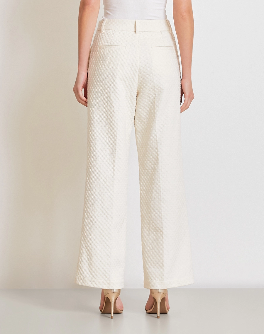 A Calça Ariadna é confeccionada em Jacquard, tecido com toque levemente encorpado que proporciona estrutura sem abrir mão do conforto. 