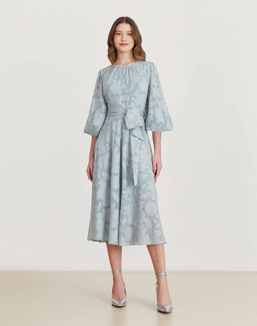 Vestido midi em jacquard floral azul, com mangas bufantes, faixa na cintura e caimento elegante. Ideal para eventos formais.