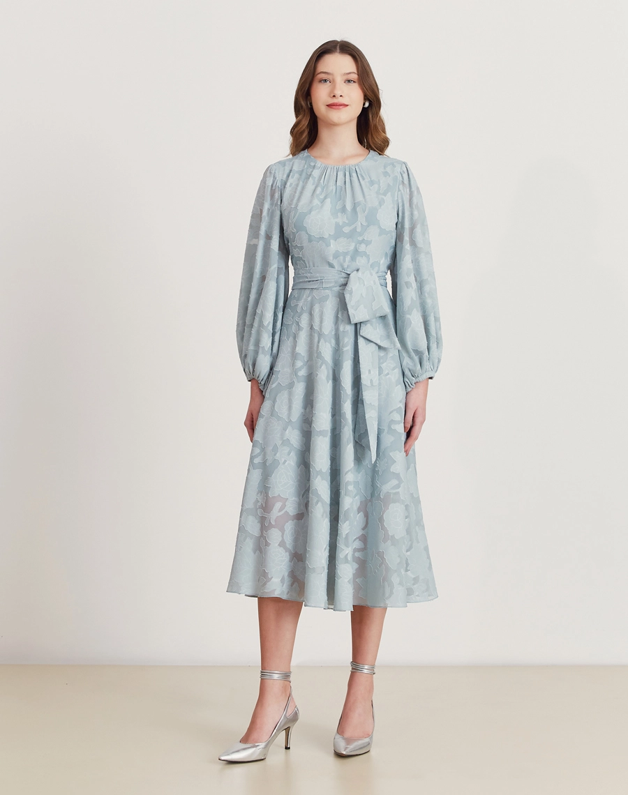 Vestido midi em jacquard floral azul, com mangas bufantes, faixa na cintura e caimento elegante. Ideal para eventos formais.