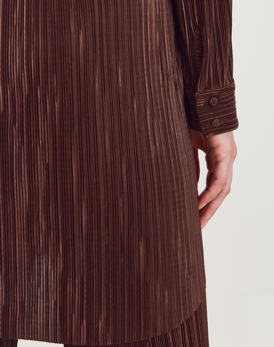 A Camisa Daisy é confeccionada em malha plissada, tecido que cria movimento, leveza e um efeito visual elegante.