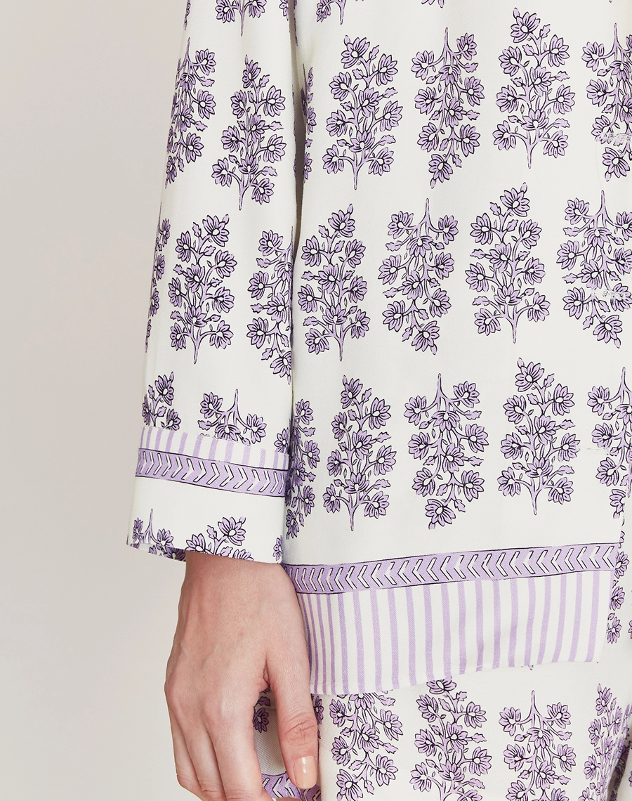 A Camisa Lylla é confeccionada em viscose estampada, um tecido leve e suave ao toque, oferecendo leveza e frescor ao vestir. Com estampa floral Amissima exclusiva em tons de roxo sobre fundo claro.