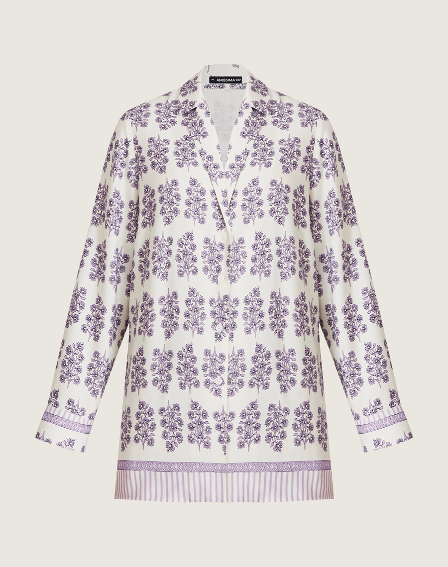 A Camisa Lylla é confeccionada em viscose estampada, um tecido leve e suave ao toque, oferecendo leveza e frescor ao vestir. Com estampa floral Amissima exclusiva em tons de roxo sobre fundo claro.