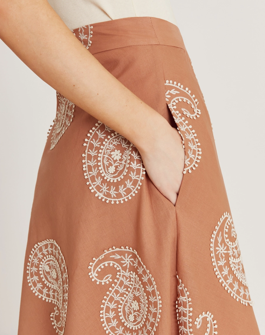 A Saia Midi Camily é confeccionada em tecido de algodão bordado. É versátil para looks elegantes ou descontraídos em passeios, viagens e eventos casuais.