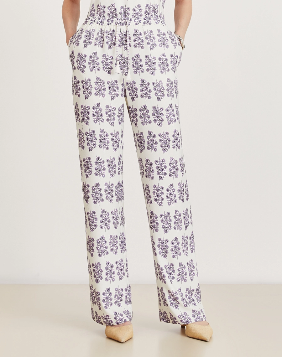 A Calça Lylla é confeccionada em viscose estampada, um tecido leve e suave ao toque, oferecendo leveza e frescor ao vestir. Com estampa floral Amissima exclusiva em tons de roxo sobre fundo claro. 