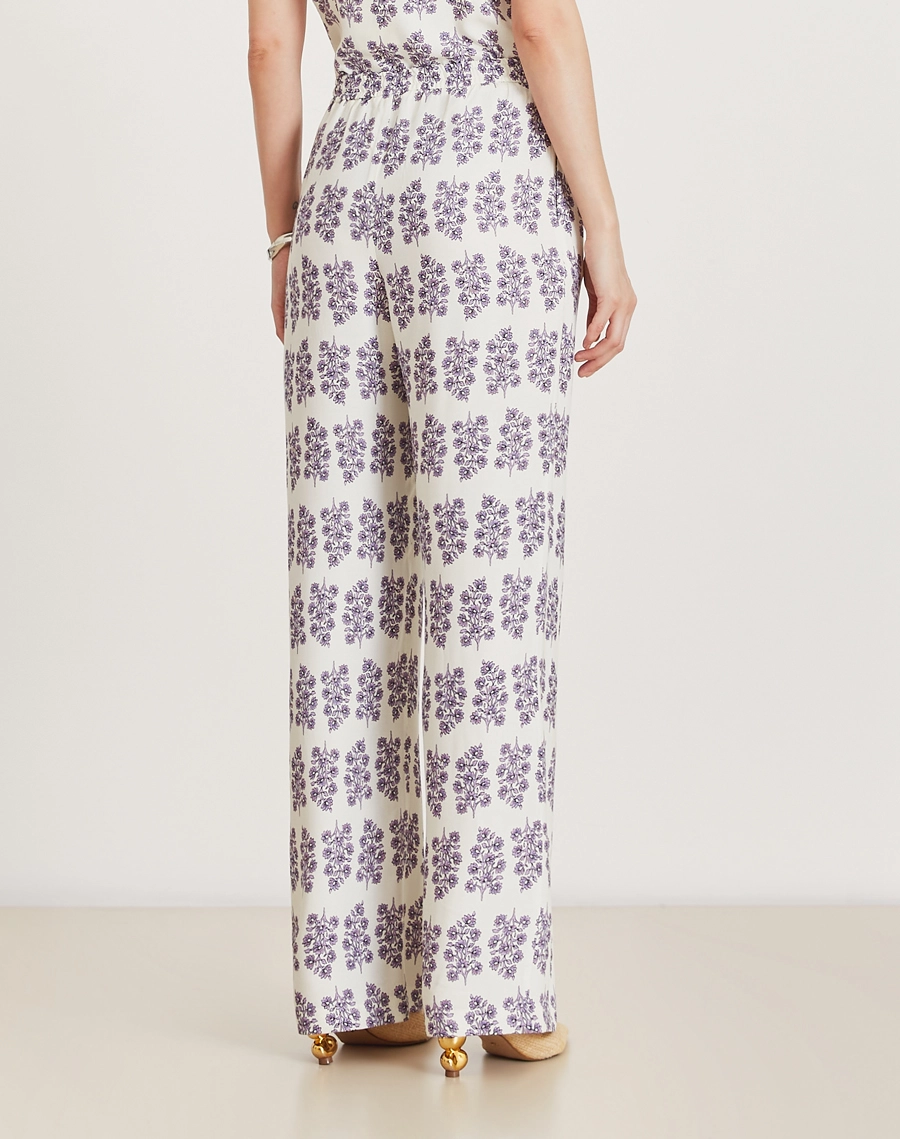 A Calça Lylla é confeccionada em viscose estampada, um tecido leve e suave ao toque, oferecendo leveza e frescor ao vestir. Com estampa floral Amissima exclusiva em tons de roxo sobre fundo claro. 