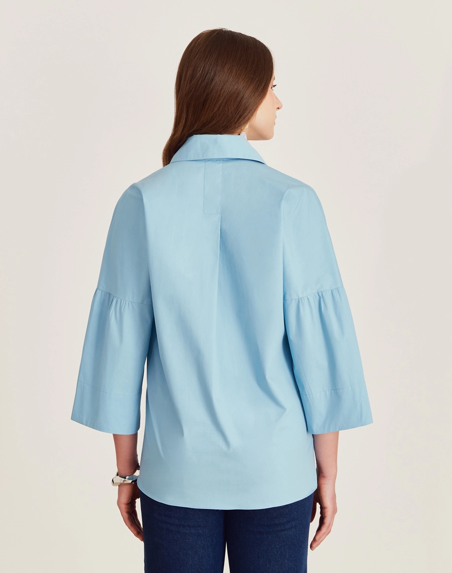 A Blusa Aisha é confeccionada em Cotton Paper, um tecido levemente estruturado mas suave ao toque, oferecendo leveza e frescor ao vestir. 