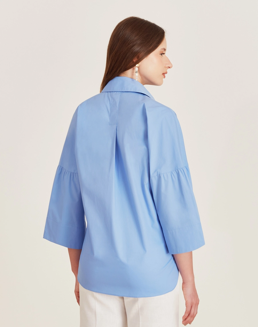 A Blusa Aisha é confeccionada em Cotton Paper, um tecido levemente estruturado mas suave ao toque, oferecendo leveza e frescor ao vestir. 