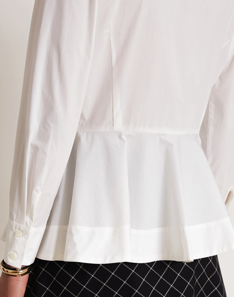 A Camisa Nina é confeccionada em tecido Paper, leve e estruturado, com toque suave e aspecto levemente encorpado, que mantém a forma da peça com elegância.