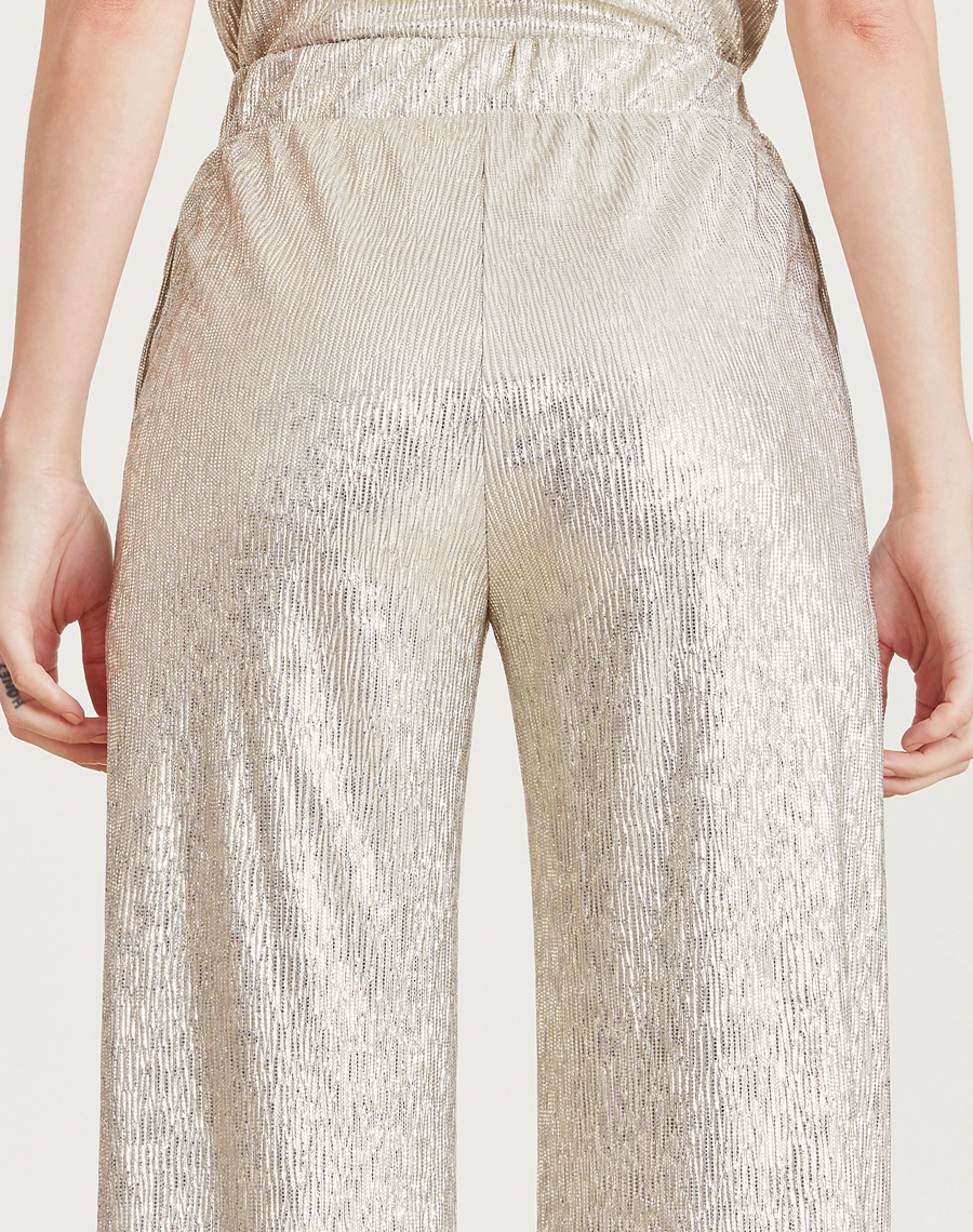 A Calça Alicia é confeccionada em Glam Foil, tecido acetinado com caimento leve e toque sofisticado, ideal para looks elegantes e contemporâneos.