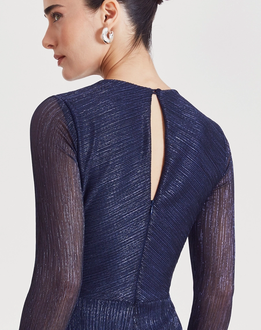 Vestido Midi Erica confeccionado em malha plissada metálica, tecido leve e confortável, caracterizado por sua textura elegante e cheia de movimento.