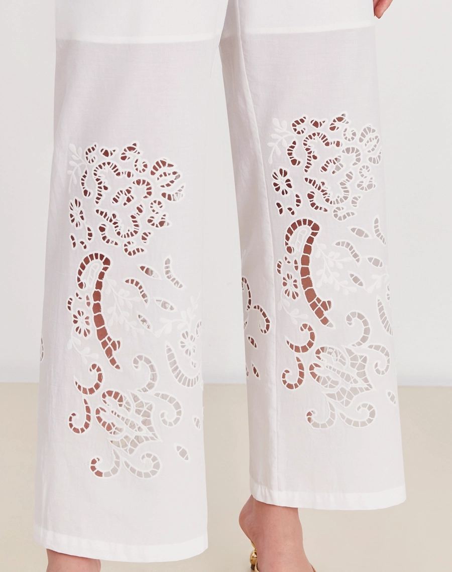 A Calça Elliot é confeccionada em laise 100% algodão, um tecido bordado e delicado que confere um toque sofisticado e atemporal à peça.