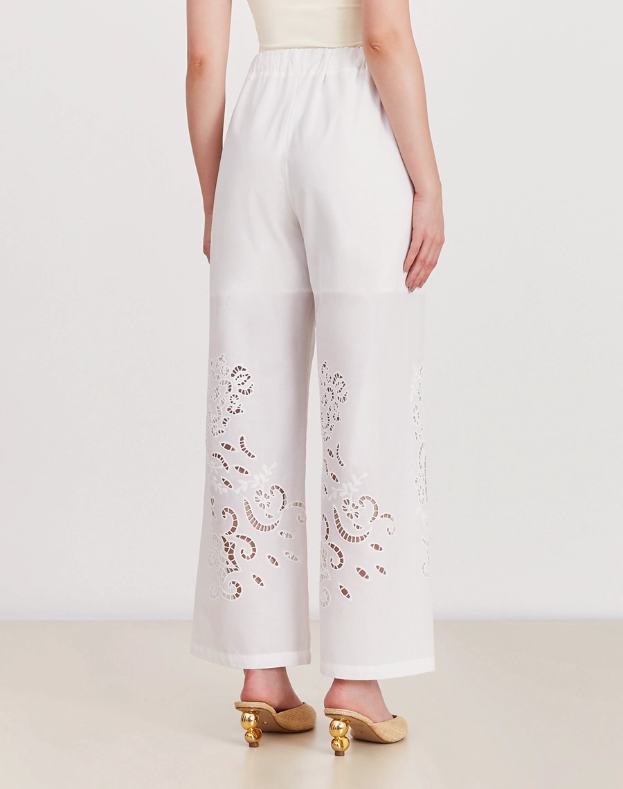 A Calça Elliot é confeccionada em laise 100% algodão, um tecido bordado e delicado que confere um toque sofisticado e atemporal à peça.