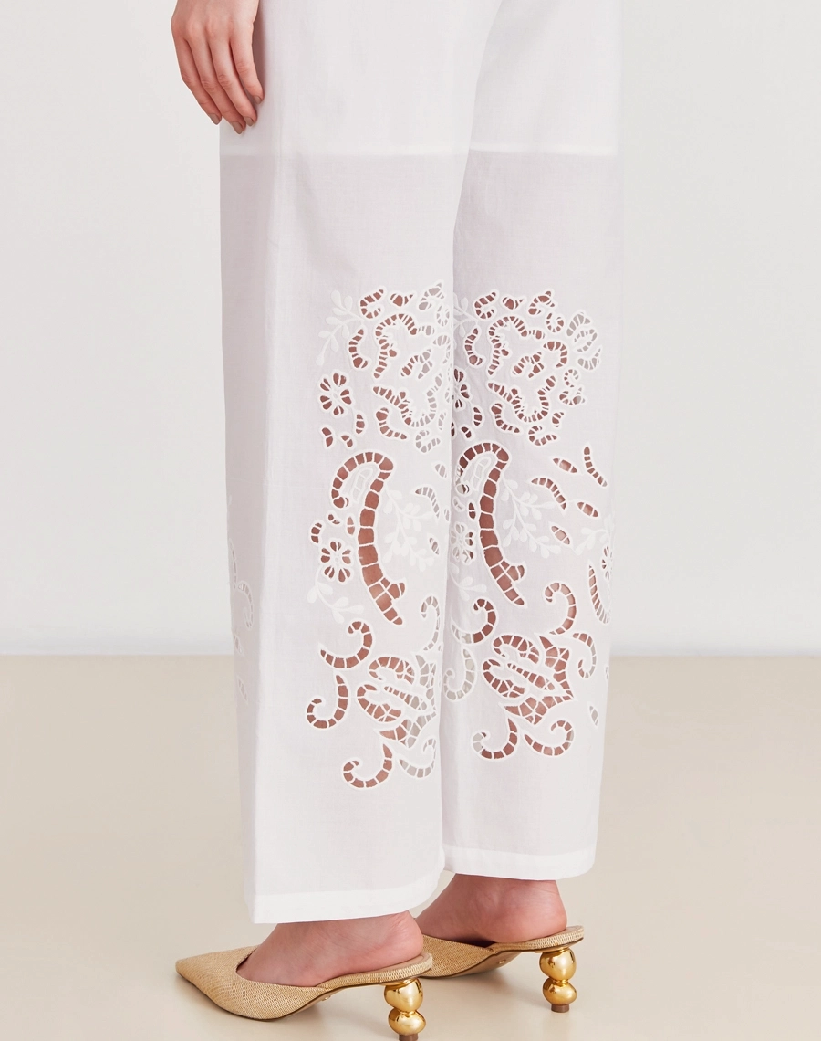 A Calça Elliot é confeccionada em laise 100% algodão, um tecido bordado e delicado que confere um toque sofisticado e atemporal à peça.