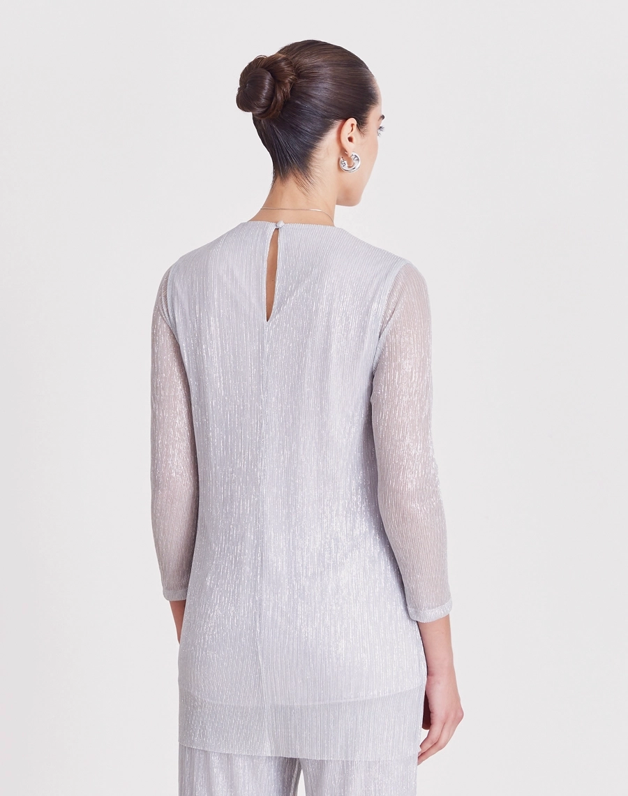 A Blusa Liliana é confeccionada em malha plissada, tecido leve e confortável, caracterizado por sua textura elegante e cheia de movimento.