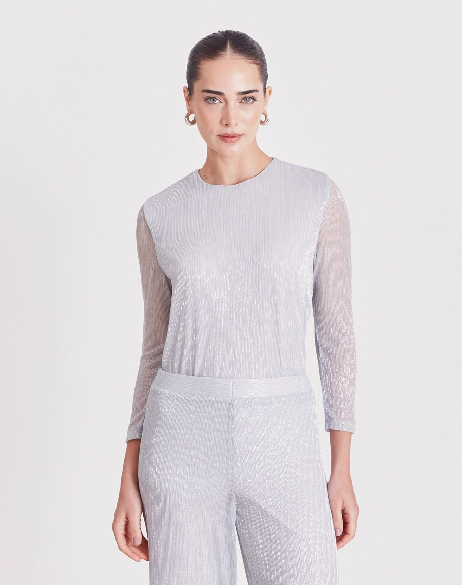 A Blusa Liliana é confeccionada em malha plissada, tecido leve e confortável, caracterizado por sua textura elegante e cheia de movimento.