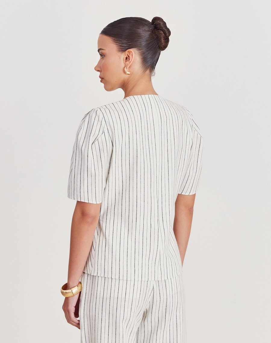 Blusa Theodora confeccionada em linho listrado, tecido leve, fresco e com toque natural, a peça oferece conforto e elegância para o dia a dia.