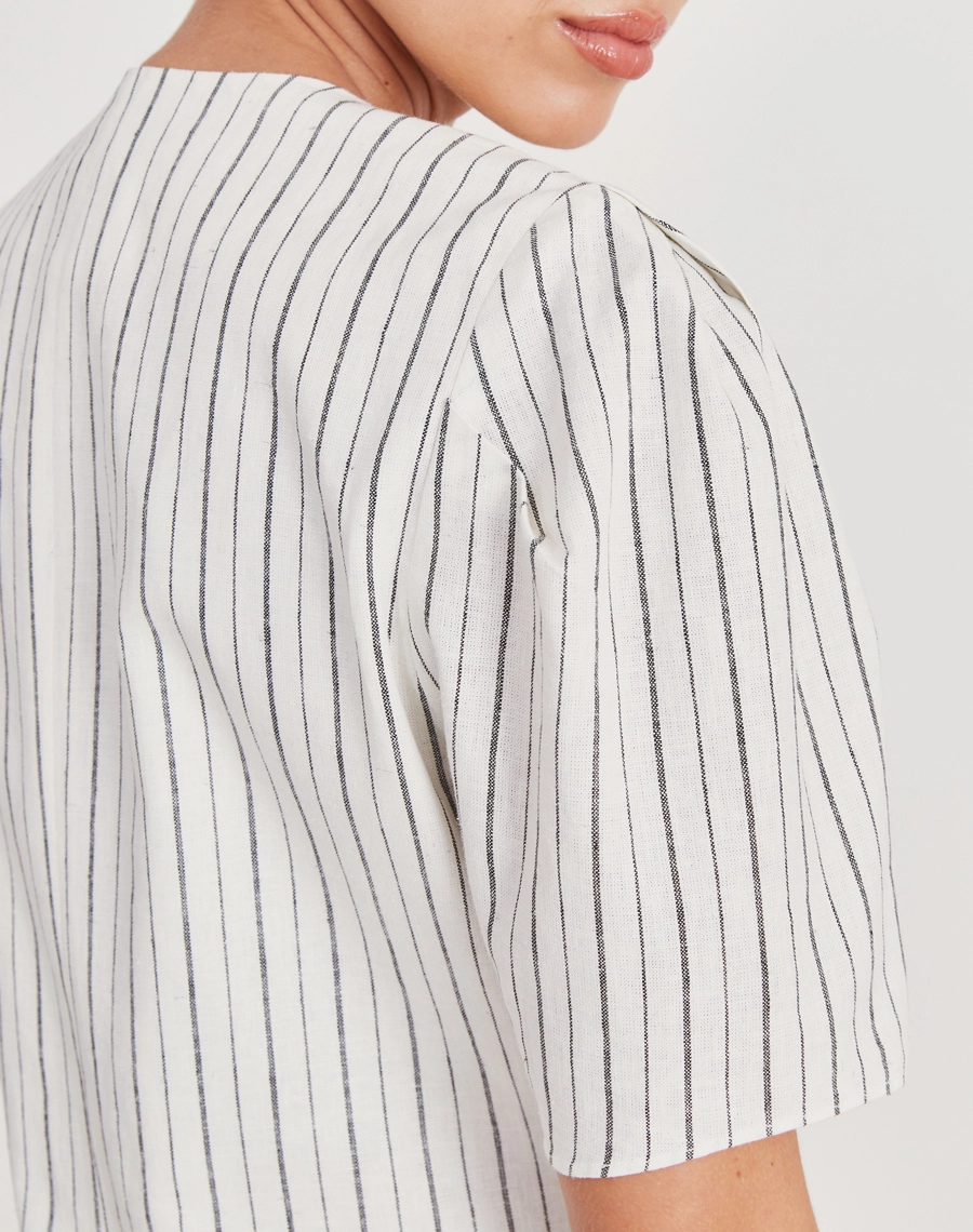 Blusa Theodora confeccionada em linho listrado, tecido leve, fresco e com toque natural, a peça oferece conforto e elegância para o dia a dia.