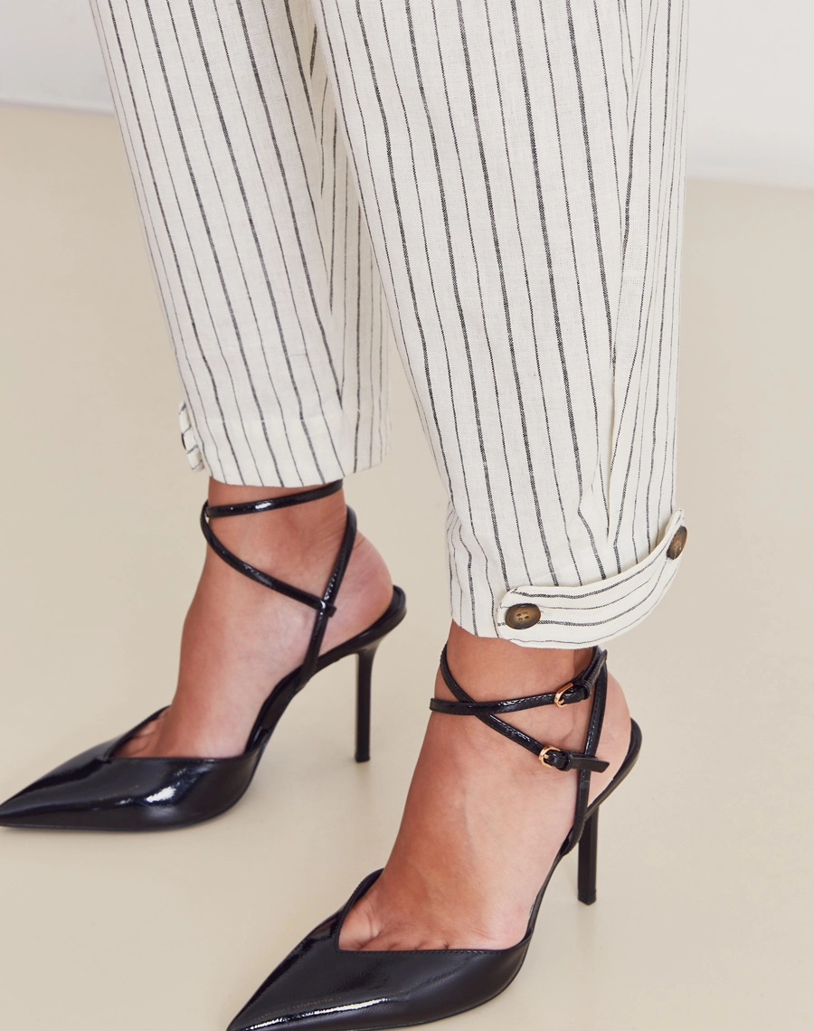 Calça Theodora confeccionada em linho listrado, tecido leve, fresco e com toque natural, a peça proporciona conforto térmico e visual sofisticado.
