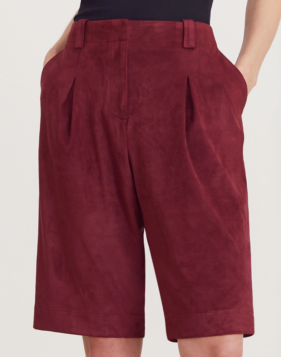 A Bermuda Elora é confeccionada em suede, um tecido conhecido pelo toque macio e acabamento levemente aveludado que remete à camurça.