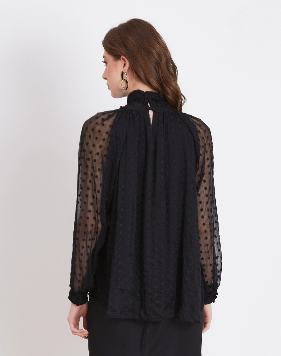 A Blusa Giseli é confeccionada em Youro bordado, tecido leve e sofisticado, com textura e aplicações delicadas que adicionam profundidade e riqueza ao visual.