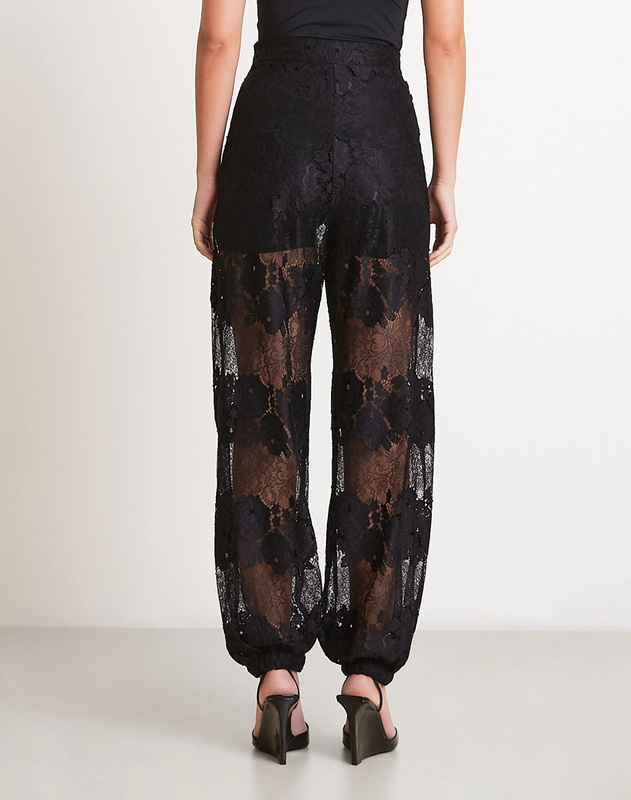 A Calça Malu é confeccionada em renda sofisticada, tecido com desenho floral marcante e transparência elegante que valoriza a peça com leveza e modernidade.