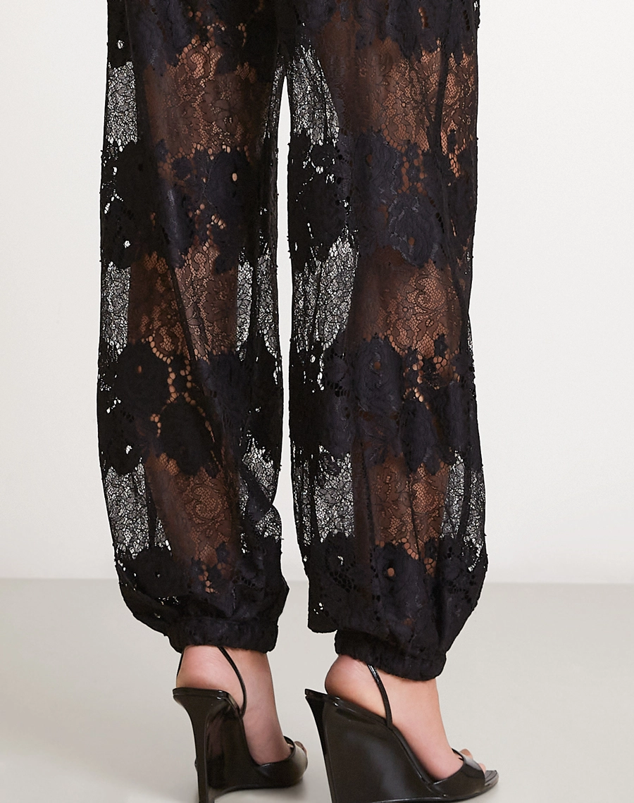 A Calça Malu é confeccionada em renda sofisticada, tecido com desenho floral marcante e transparência elegante que valoriza a peça com leveza e modernidade.