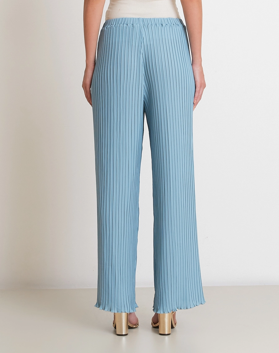 A Calça Norah é confeccionada em crepinho plissado, com toque leve e caimento fluido.