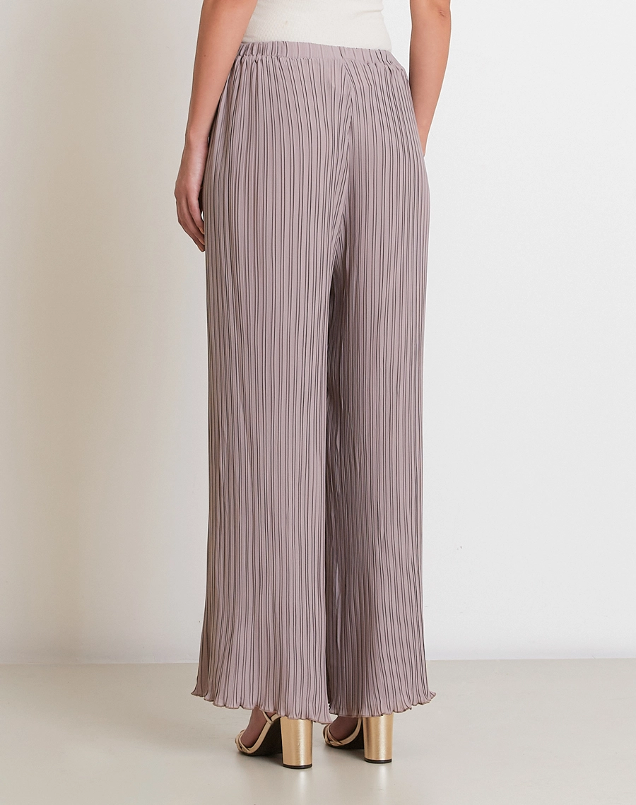 A Calça Norah é confeccionada em crepinho plissado, com toque leve e caimento fluido.