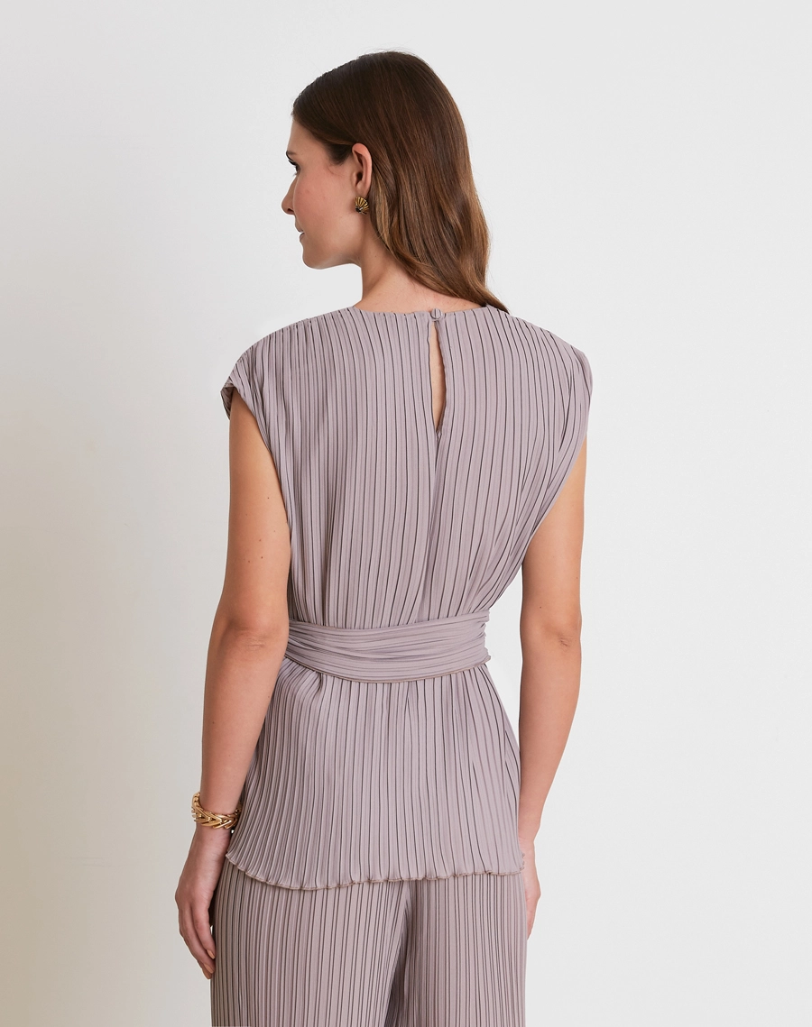 A Blusa Norah é confeccionada em crepinho plissado, tecido de textura delicada e caimento leve, garantindo movimento e fluidez ao visual.
