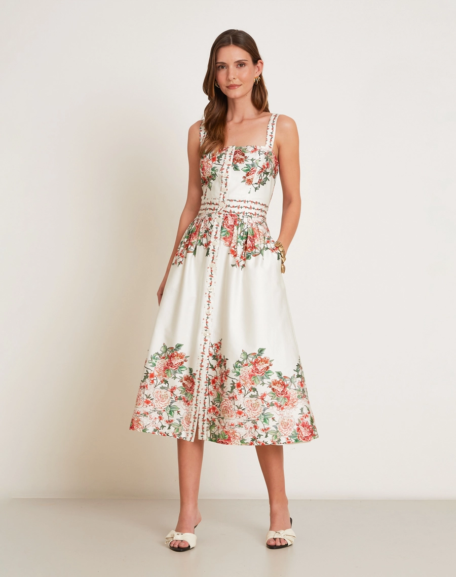 O Vestido Midi Kira em Tricoline Estampada, peça de modelagem acinturada e evasê, com decote reto e alças finas.