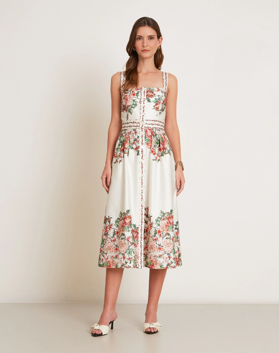 O Vestido Midi Kira em Tricoline Estampada, peça de modelagem acinturada e evasê, com decote reto e alças finas.