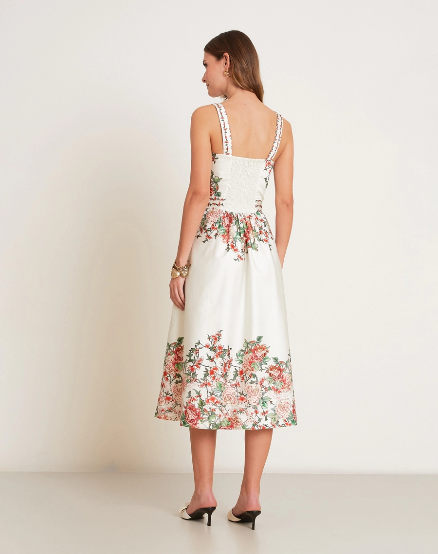 O Vestido Midi Kira em Tricoline Estampada, peça de modelagem acinturada e evasê, com decote reto e alças finas.