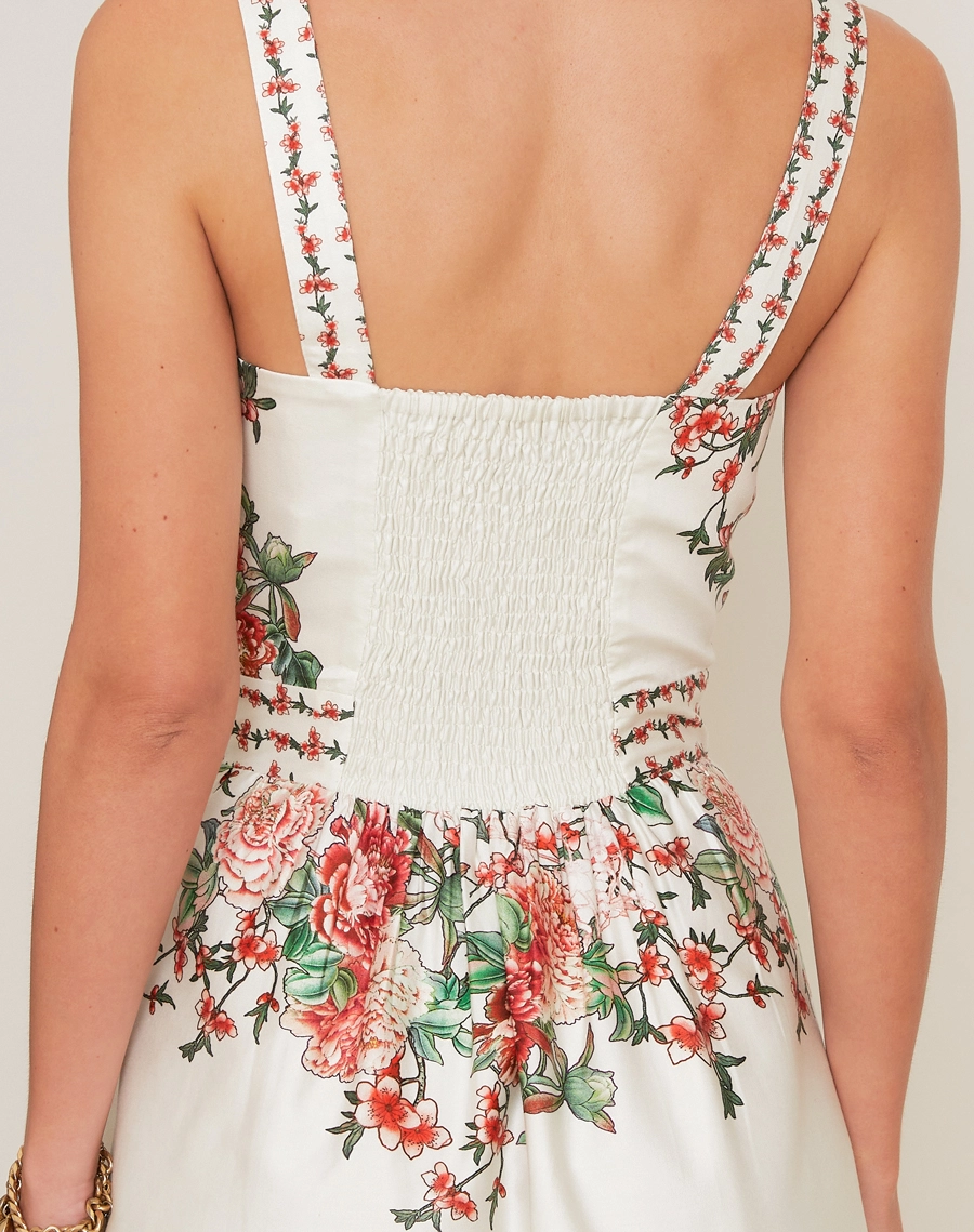 O Vestido Midi Kira em Tricoline Estampada, peça de modelagem acinturada e evasê, com decote reto e alças finas.