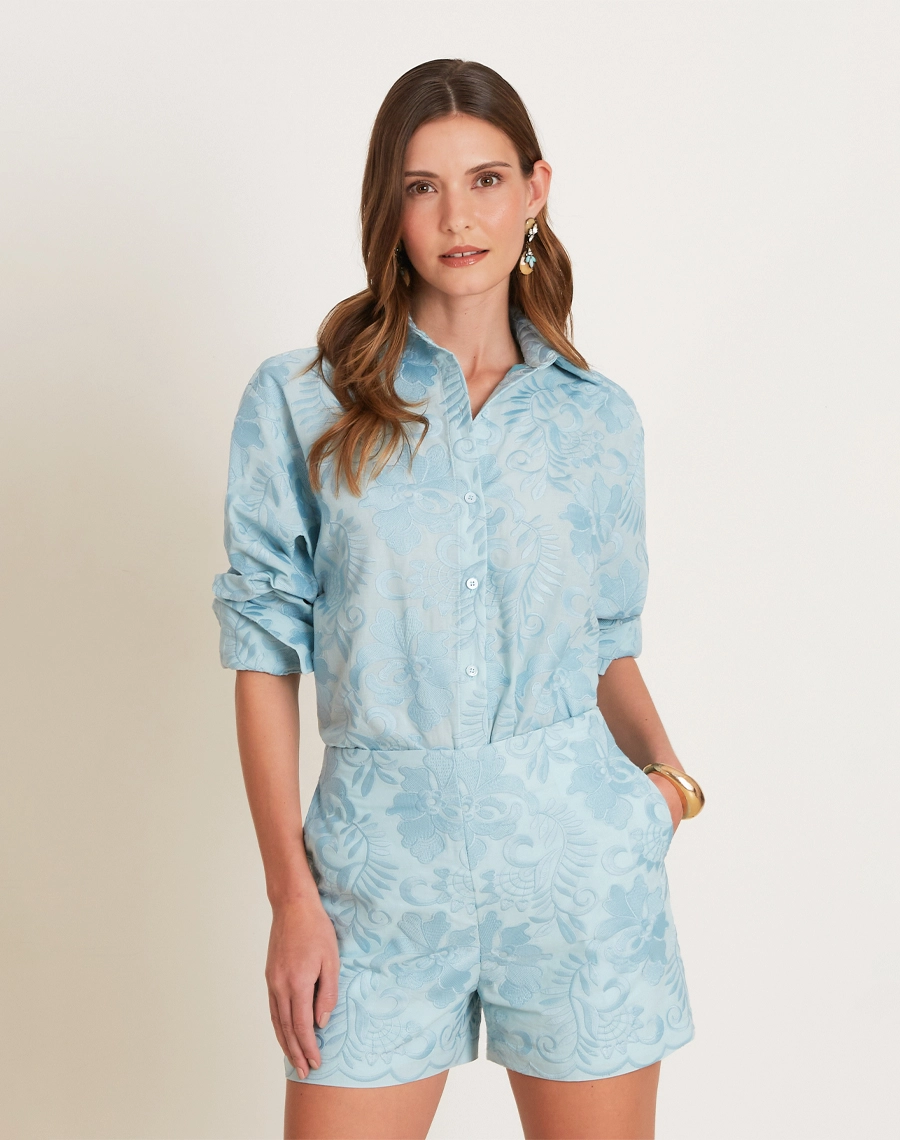 A Camisa Arabela é confeccionada em algodão bordado, com textura delicada e padronagem floral que traz charme ao visual.