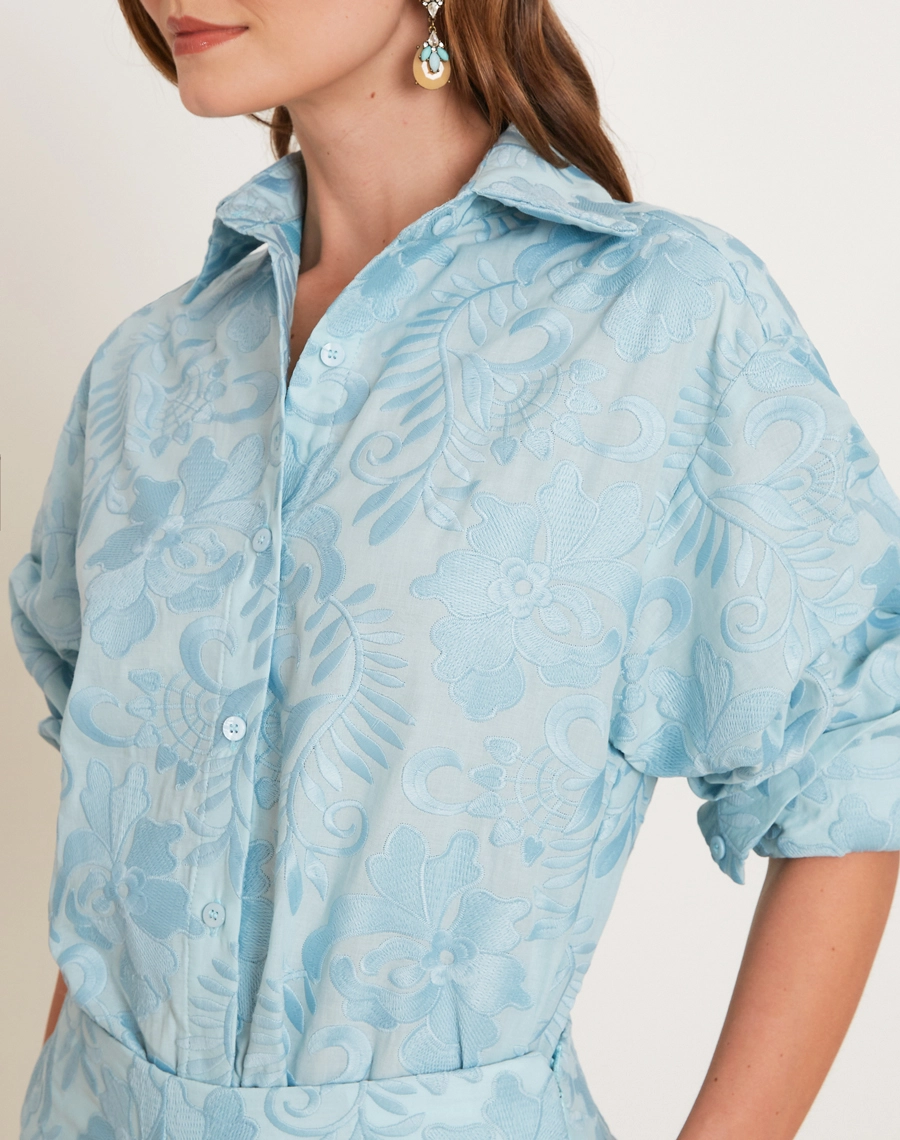 A Camisa Arabela é confeccionada em algodão bordado, com textura delicada e padronagem floral que traz charme ao visual.