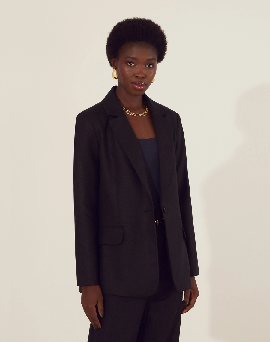 Blazer Maya confeccionado em linho, um tecido estruturado com toque rústico. Com gola clássica, manga longa com ombreiras para mais estrutura, 