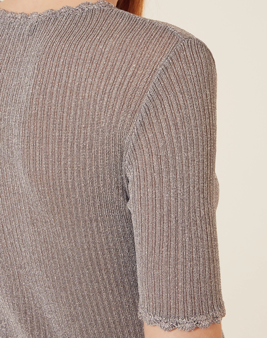Blusa confeccionada em tecido misto metalizado, com toque fluido. 
Possui gola redonda e manga curta, possui detalhe de crochê no decote e nas mangas. 
Possui uma silhueta mais justa e elegante. 
A blusa metalizada é uma opção ideal para ser usado em uma noite mais sofisticada.