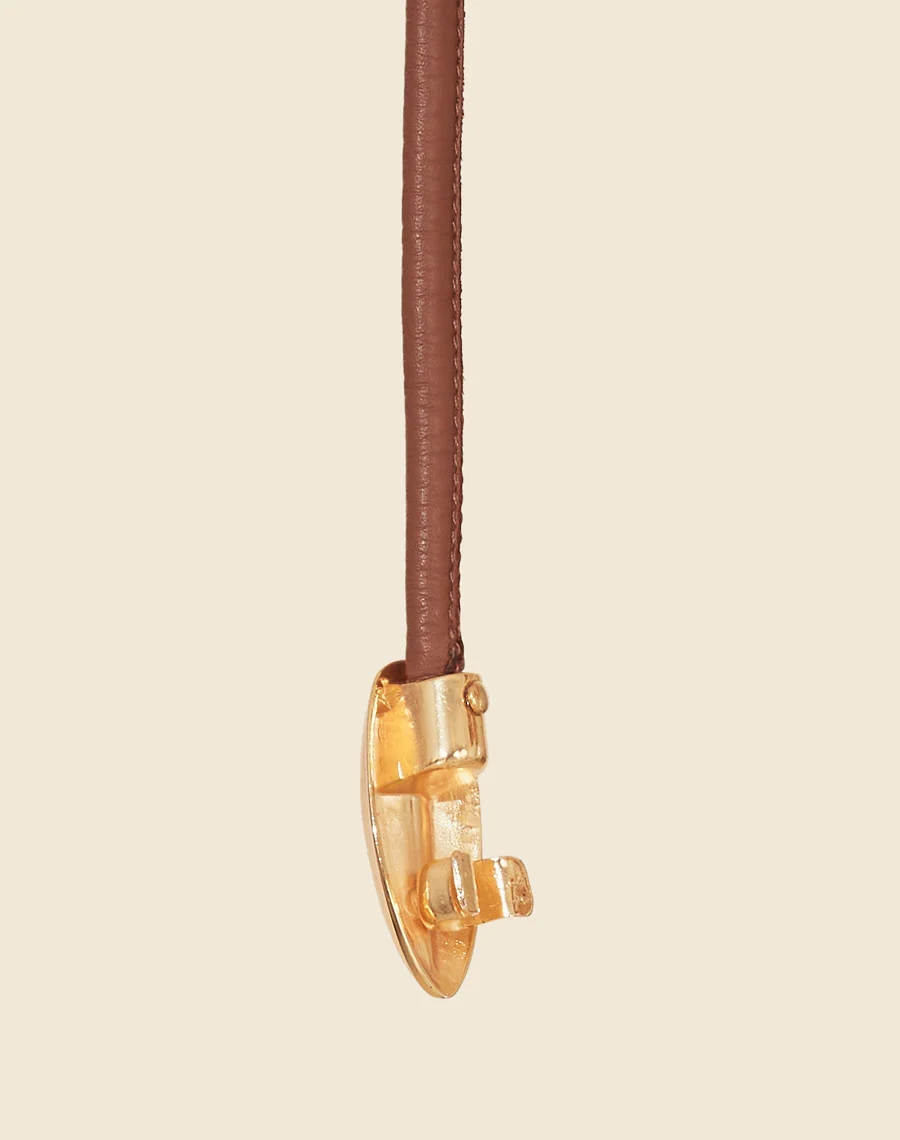 Cinto Anyka é uma peça sofisticada e minimalista, confeccionada em couro de alta qualidade. <br/>
Com um design fino e detalhe central em metal dourado, ele adiciona um toque de modernidade e elegância a qualquer look. <br/>
Ideal para complementar vestidos, saias e calças de cintura alta, este cinto ajustável garante um caimento perfeito, valorizando a silhueta com sutileza. <br/>