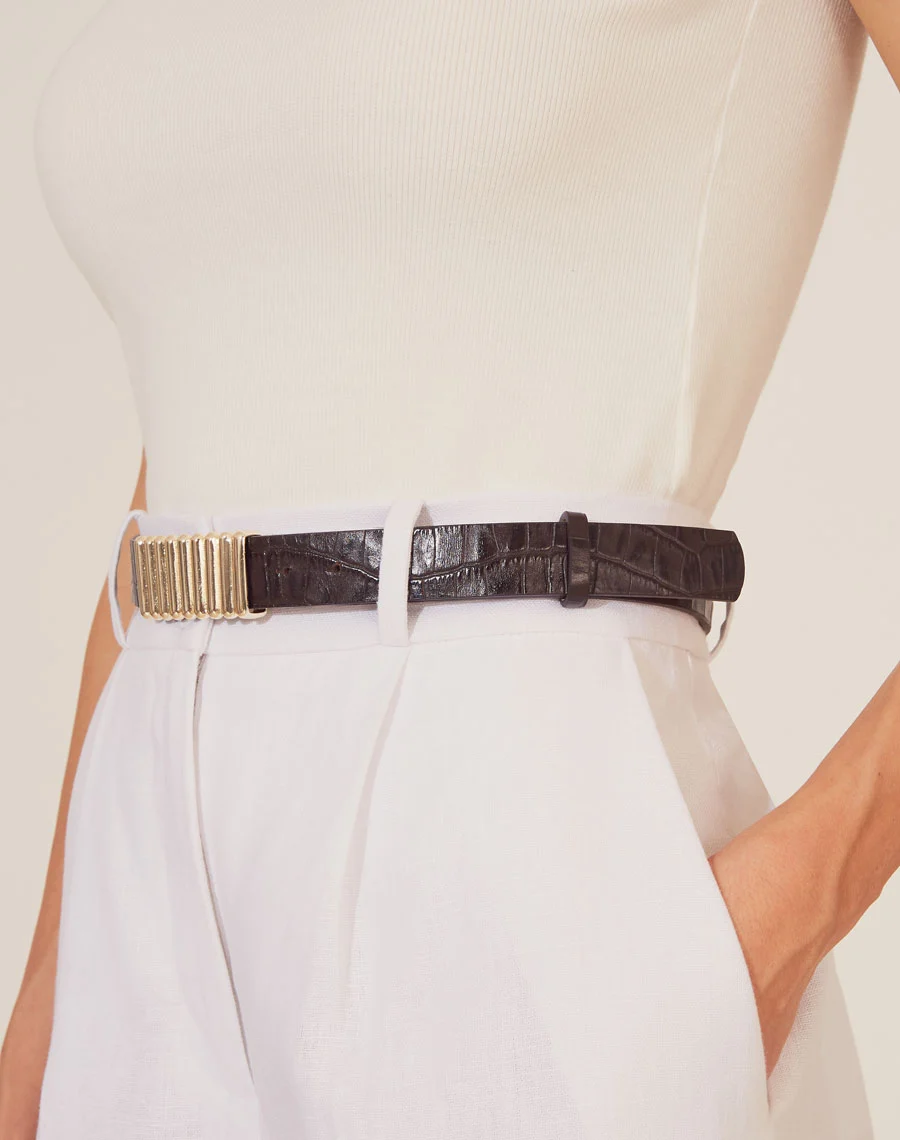 Cinto Kendal é um acessório marcante e sofisticado, confeccionado em couro com textura croco, que adiciona um toque de elegância contemporânea a qualquer produção.<br/>
O detalhe em metal dourado no centro oferece um contraste moderno e luxuoso, tornando-o o complemento perfeito para peças de cintura alta.<br/> 
Com um design ajustável, o cinto realça a silhueta com estilo e sofisticação. Ideal para quem busca um acessório diferenciado e atemporal, capaz de elevar tanto looks casuais quanto mais formais.<br/>