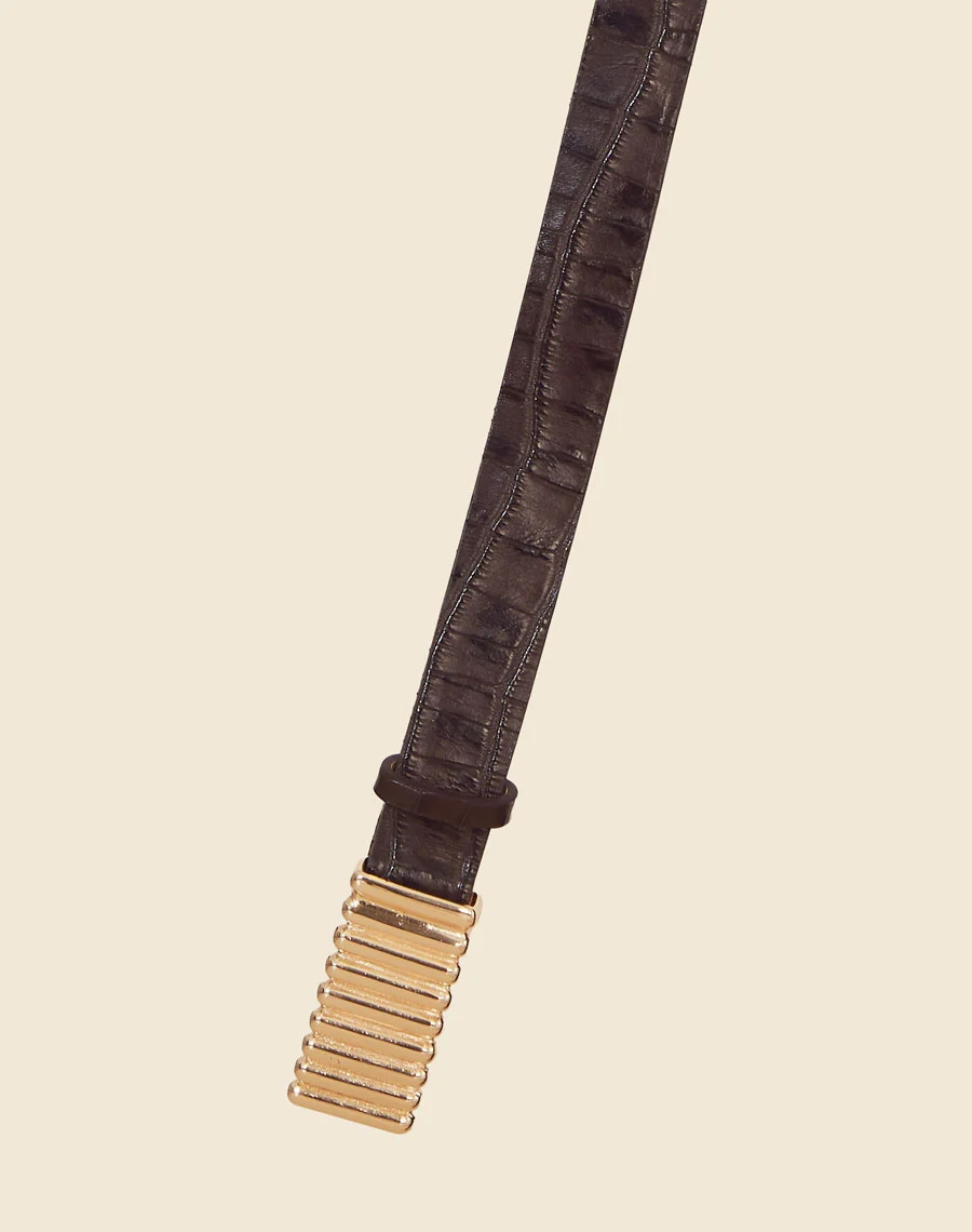 Cinto Kendal é um acessório marcante e sofisticado, confeccionado em couro com textura croco, que adiciona um toque de elegância contemporânea a qualquer produção.<br/>
O detalhe em metal dourado no centro oferece um contraste moderno e luxuoso, tornando-o o complemento perfeito para peças de cintura alta.<br/> 
Com um design ajustável, o cinto realça a silhueta com estilo e sofisticação. Ideal para quem busca um acessório diferenciado e atemporal, capaz de elevar tanto looks casuais quanto mais formais.<br/>