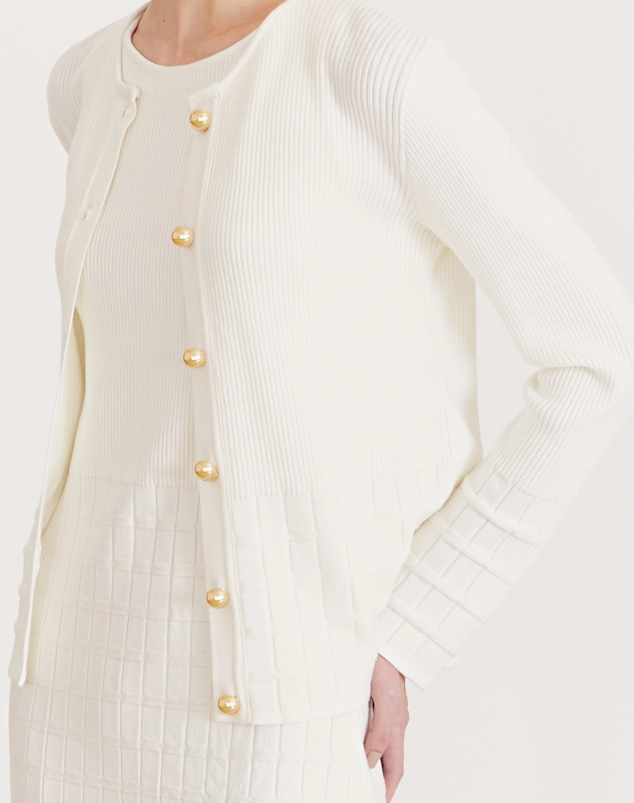 Cardigan Helena em tricot feminino com botões dourados, textura canelada e quadriculada. Elegância e conforto para dias frescos.