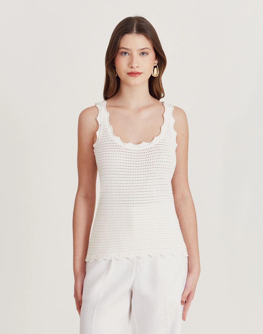 Regata de tricot feminina com babados e detalhes vazados. Toque macio e visual delicado, perfeita para dias amenos e looks elegantes.