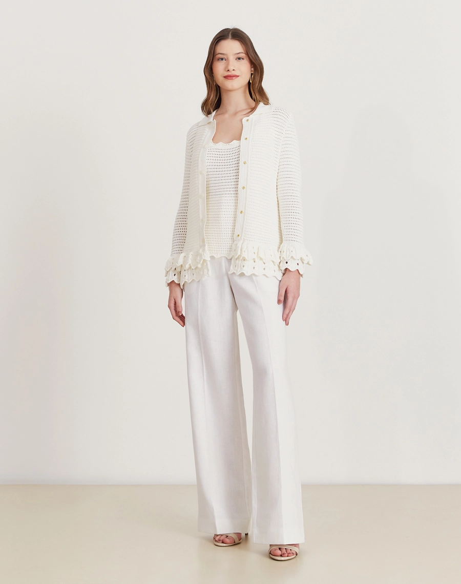 Regata de tricot feminina com babados e detalhes vazados. Toque macio e visual delicado, perfeita para dias amenos e looks elegantes.