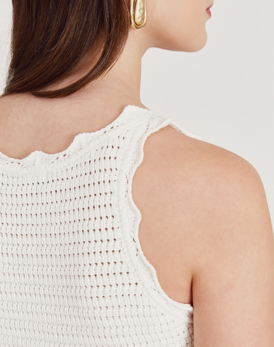 Regata de tricot feminina com babados e detalhes vazados. Toque macio e visual delicado, perfeita para dias amenos e looks elegantes.
